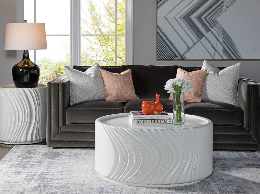 Modern living room with a gray sofa, white coffee table, and decorative items.