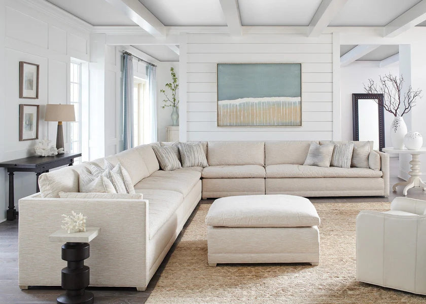 Beige sectional sofa in a living room with white walls and decorative elements.
