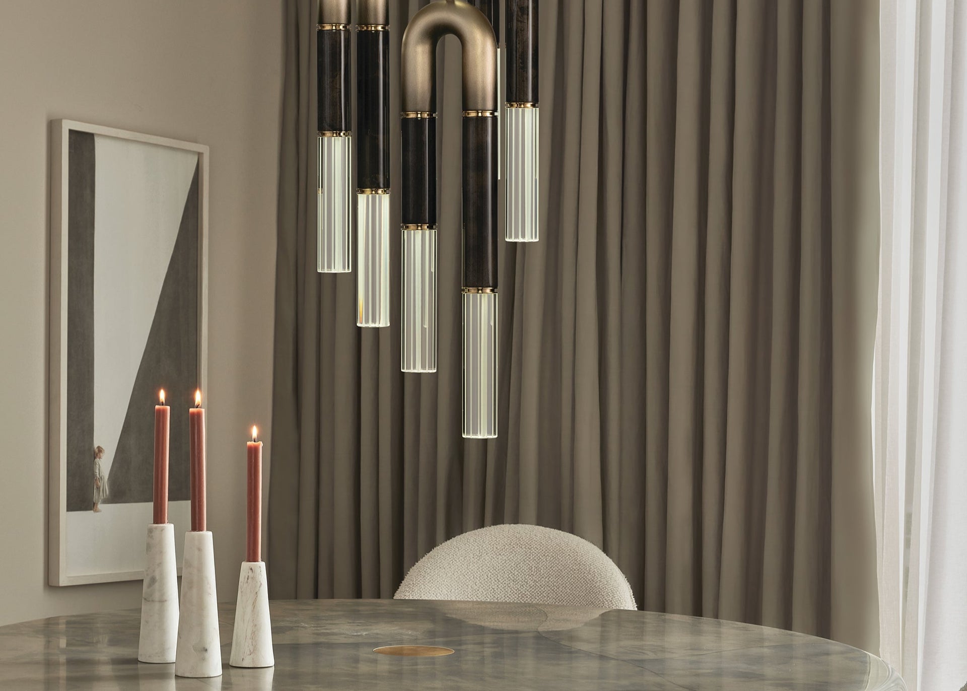 Dining room with a round marble table, chairs, and modern pendant lights.