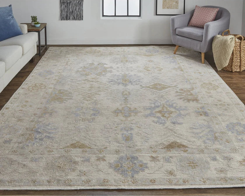 Living room with a large patterned rug, gray armchair, and white sofa.