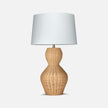 A stylish Lucena table lamp featuring a woven rattan base with an hourglass shape and a simple white lampshade on top.