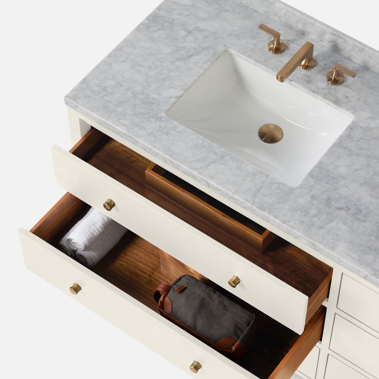 Top view of a stylish bathroom vanity base featuring a marble countertop, a white sink, and open drawers.