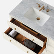 Top view of a stylish bathroom vanity base featuring a marble countertop, a white sink, and open drawers.