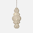 A woven hanging ilina rattan pendant light with a unique, textured shape, illuminated by soft lights, adding warmth to any interior space.