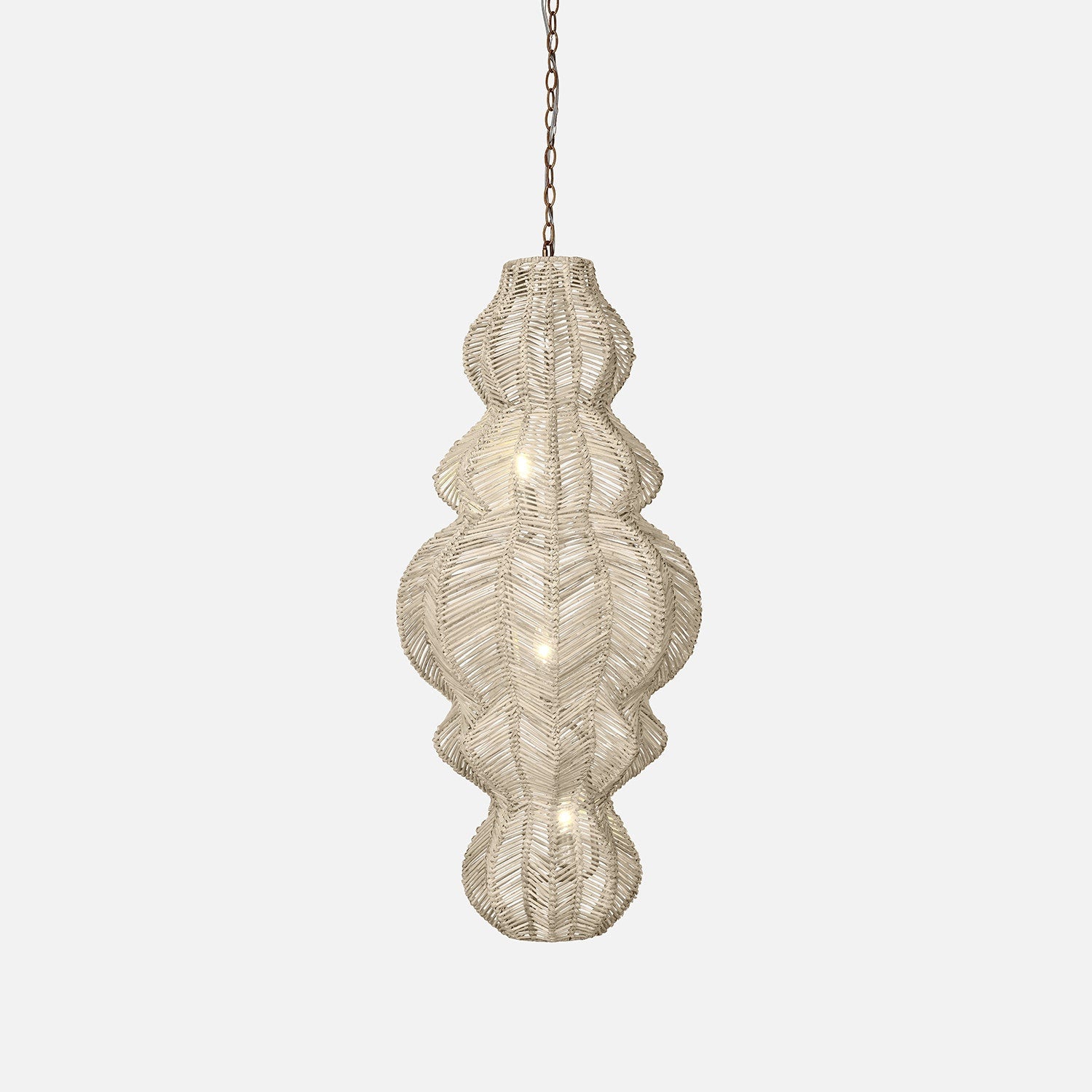 A woven hanging ilina rattan pendant light with a unique, textured shape, illuminated by soft lights, adding warmth to any interior space.