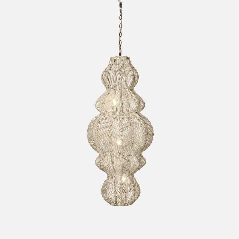 A woven hanging ilina rattan pendant light with a unique, textured shape, illuminated by soft lights, adding warmth to any interior space.
