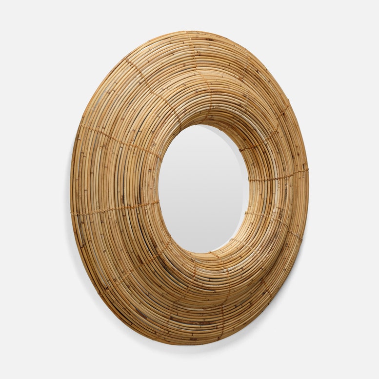 A large, roundshaped mirror with a textured bamboo frame, showcasing a natural, earthy aesthetic.
